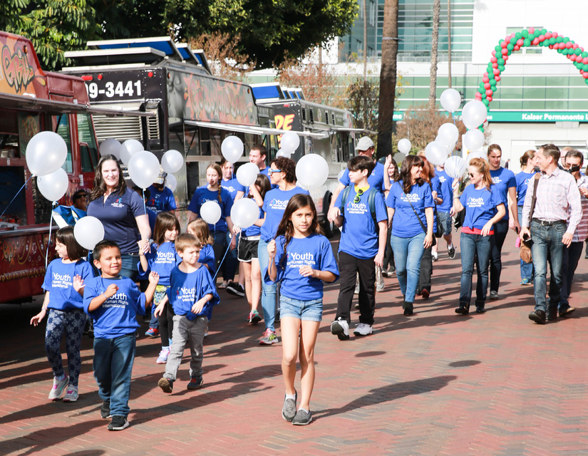 Youth walk with white balloons to spread the message of Human Rights